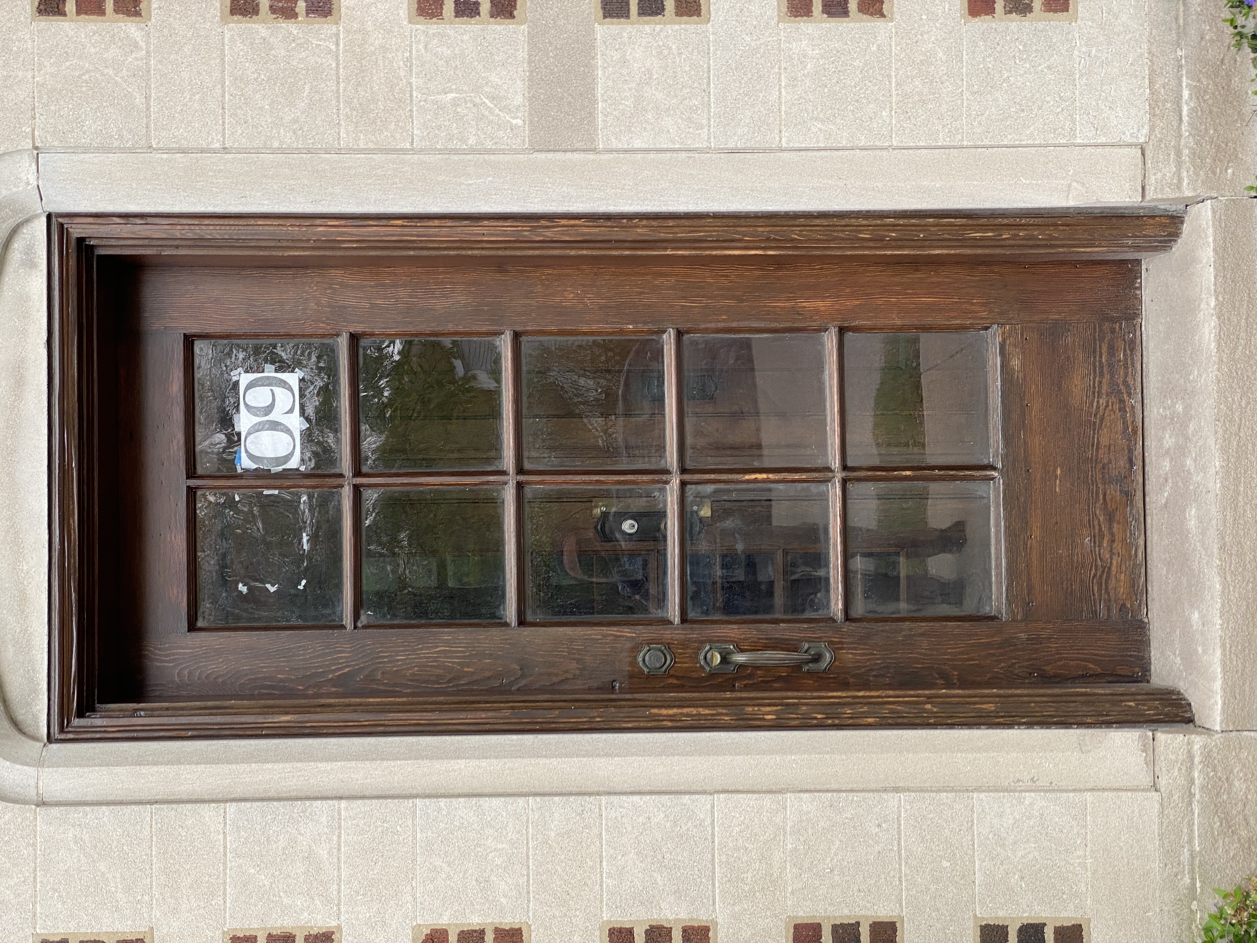 address numbers printed on printer paper taped to the inside of a door. the tape is clearly visible. half of the numbers are torn down