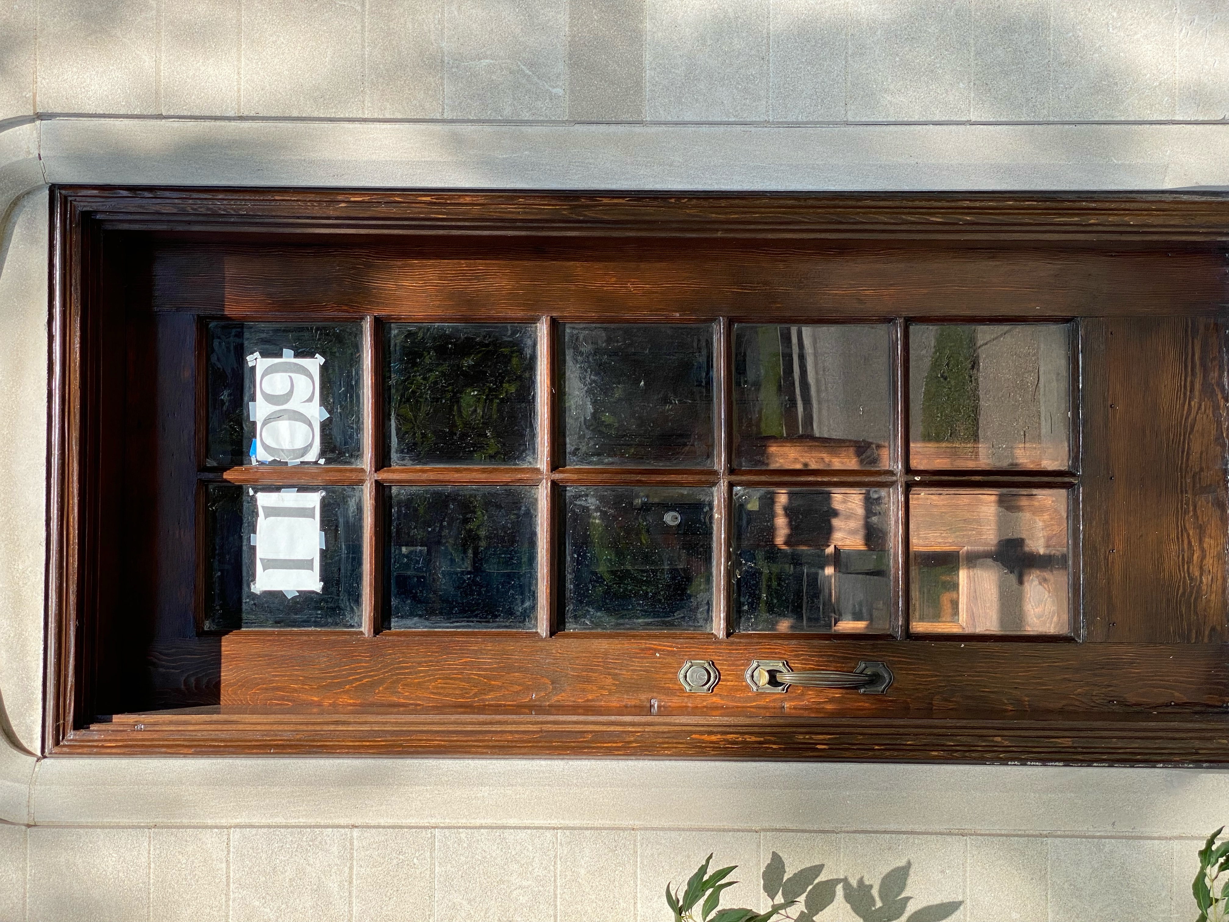 address numbers printed on printer paper taped to the inside of a door. the tape is clearly visible